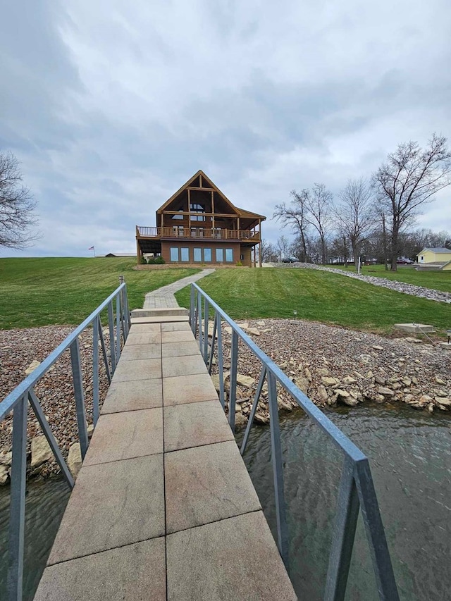 dock area with a deck with water view and a yard
