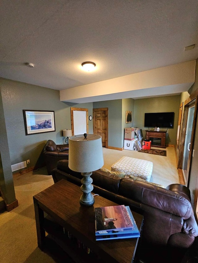living room featuring carpet, a textured ceiling, baseboards, and visible vents