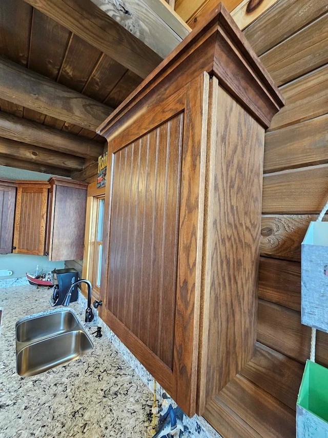 kitchen featuring wood ceiling, wooden walls, and a sink