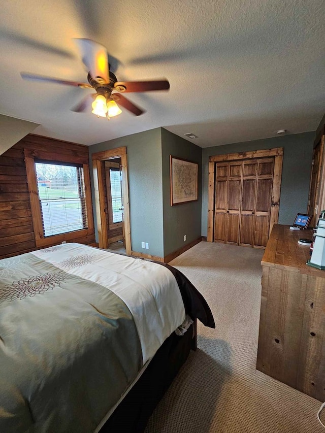 carpeted bedroom with ceiling fan, baseboards, a textured ceiling, and visible vents