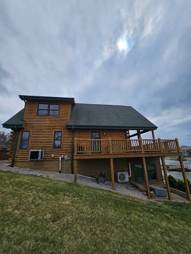 back of property with a lawn, ac unit, and roof with shingles