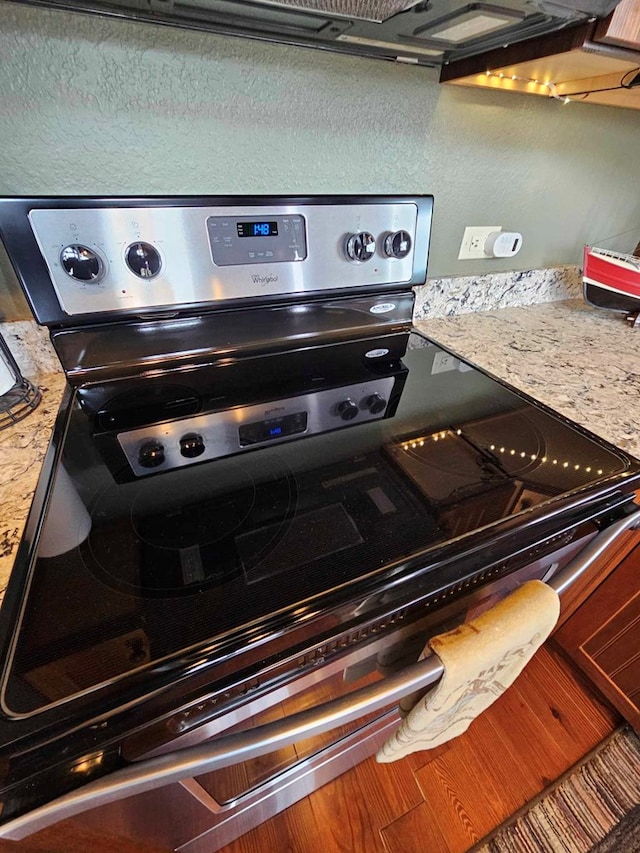 interior details with stainless steel electric stove and light countertops
