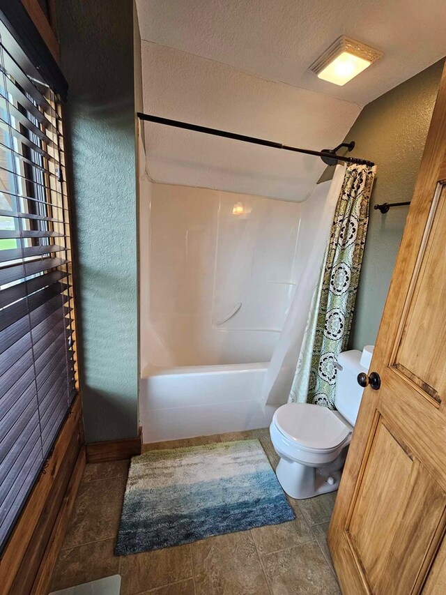 bathroom with a textured ceiling, shower / bath combination with curtain, a textured wall, toilet, and lofted ceiling