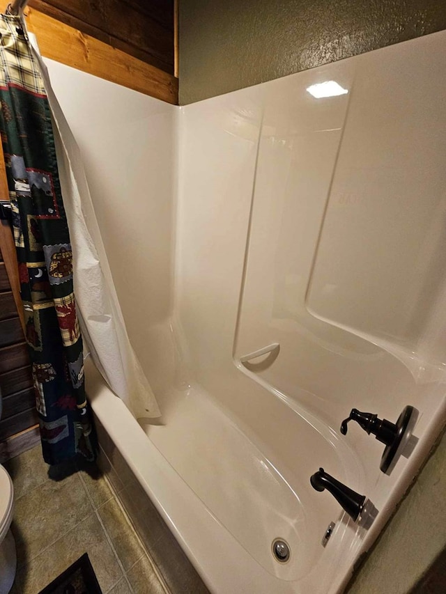 bathroom with toilet, tile patterned floors, and shower / bathtub combination with curtain