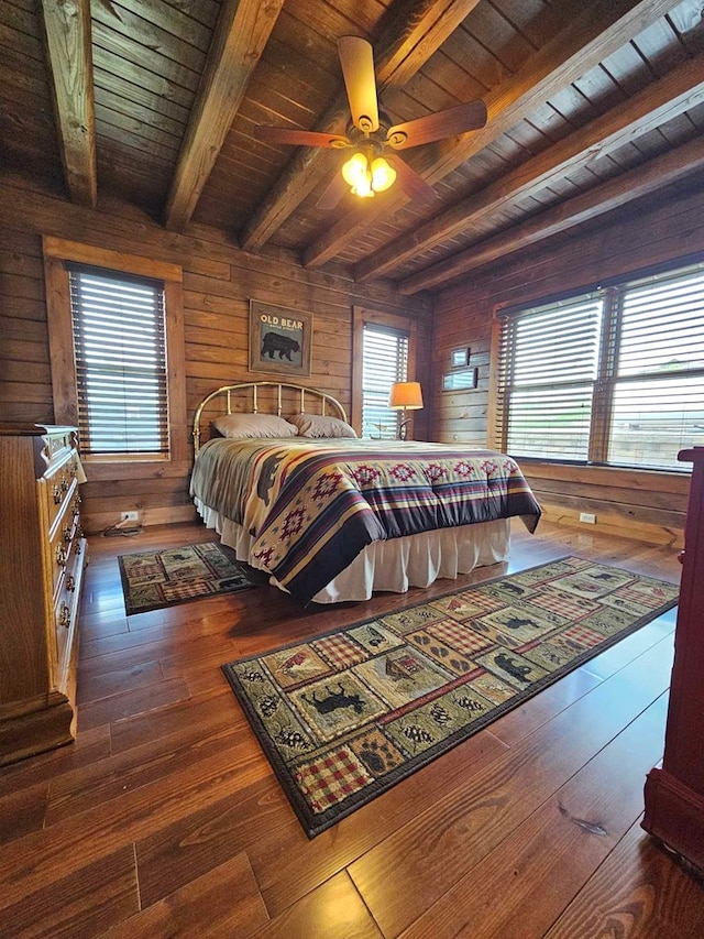 bedroom with wood ceiling, wood walls, multiple windows, and beam ceiling