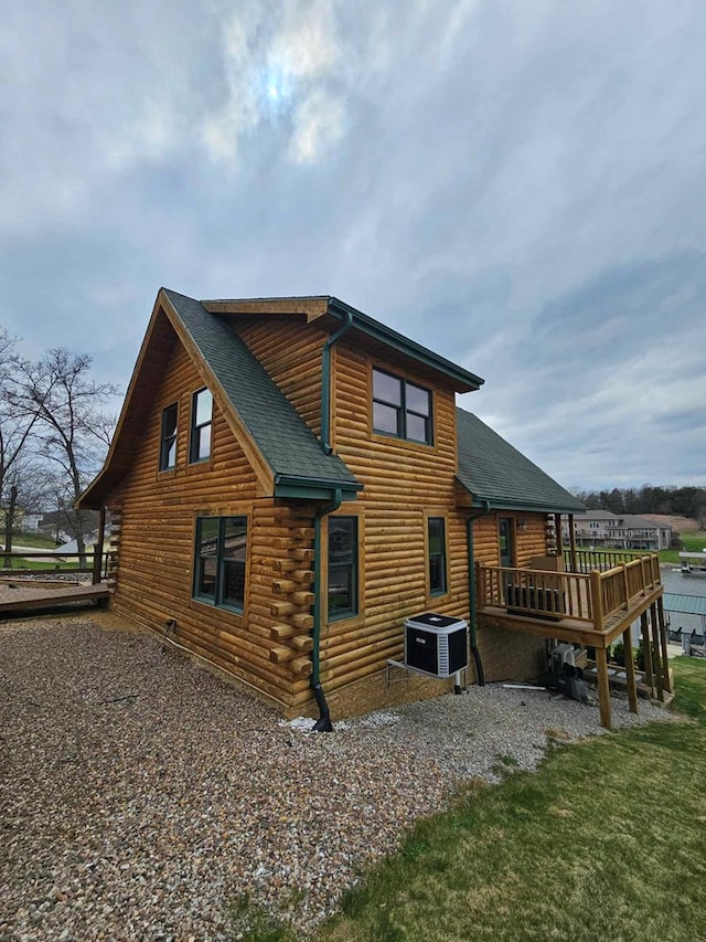 view of property exterior featuring central AC unit, roof with shingles, log exterior, and a deck