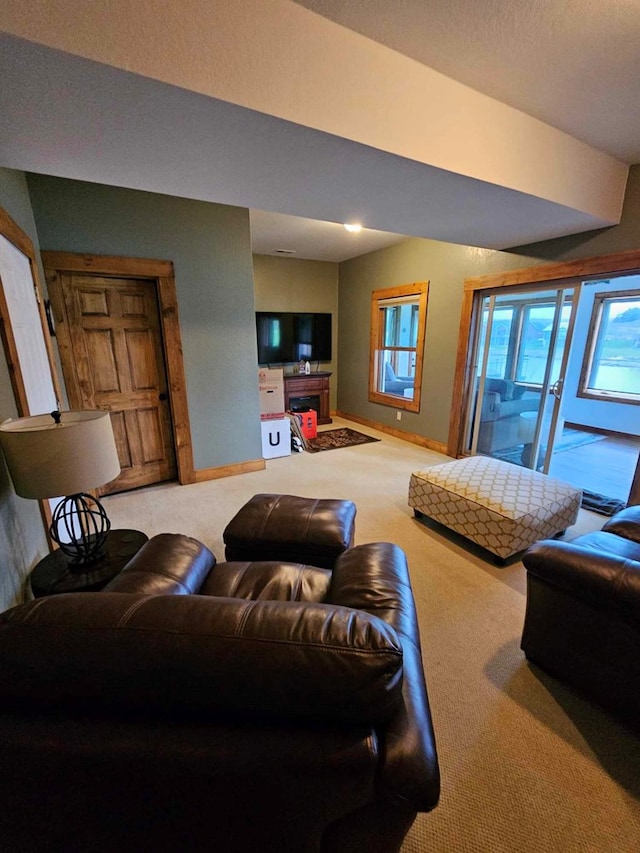 carpeted living area with a fireplace and baseboards