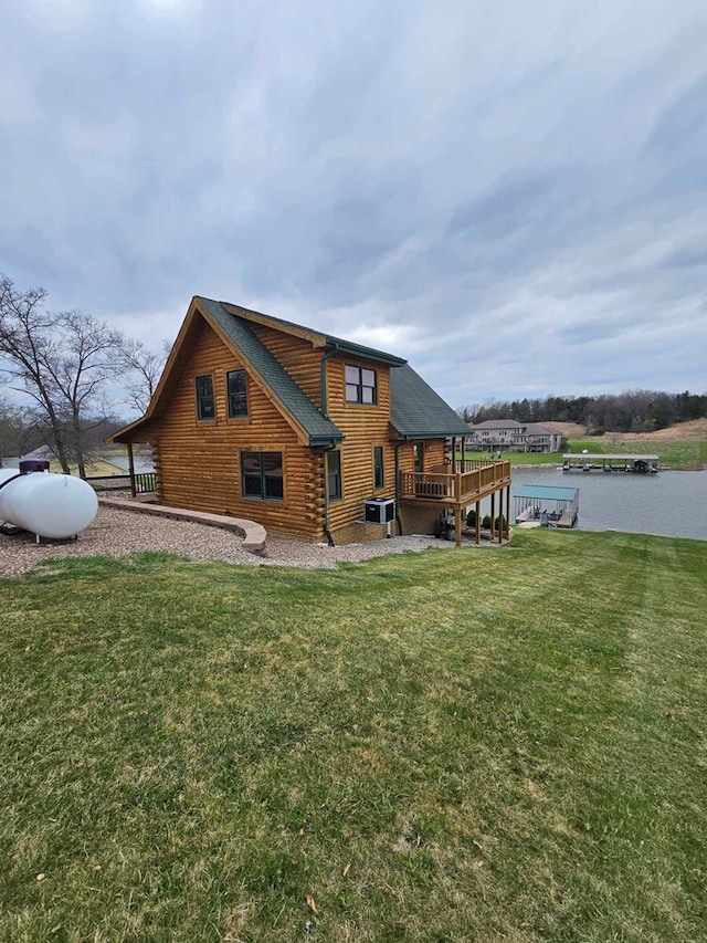 back of house featuring a deck with water view, a shingled roof, log siding, a yard, and central air condition unit