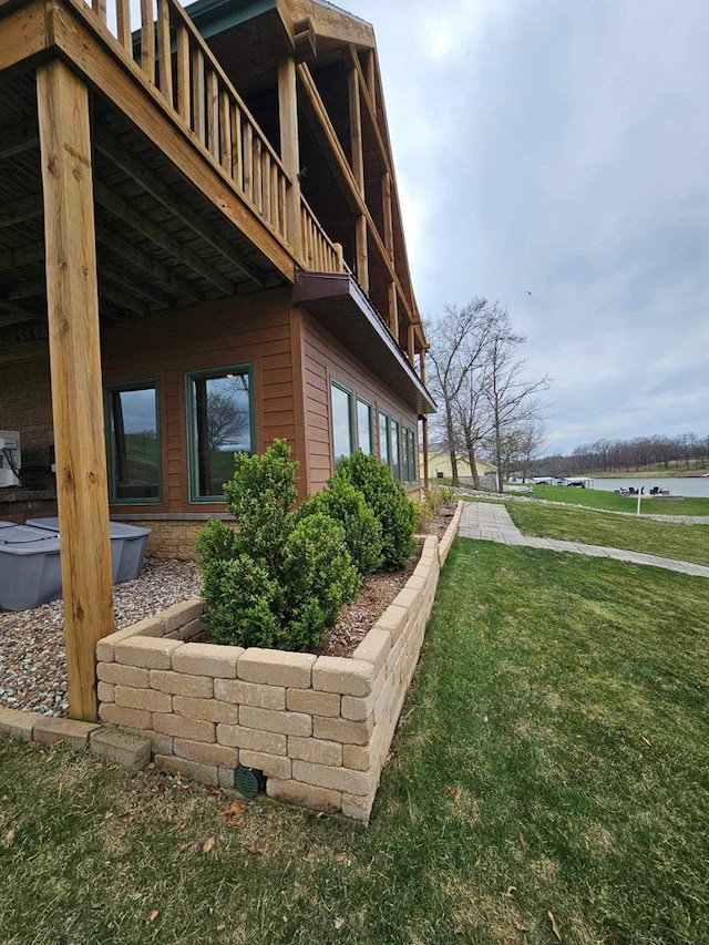 view of side of home featuring a lawn and a water view