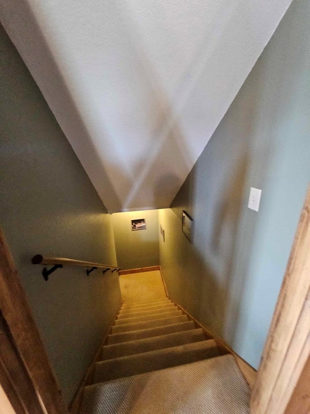 stairs featuring lofted ceiling and carpet