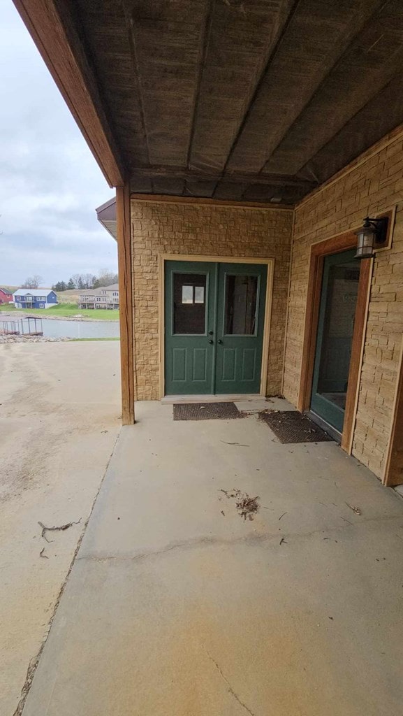 property entrance featuring a patio area and stone siding