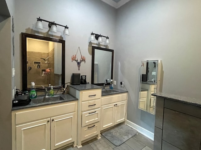 bathroom featuring tile patterned flooring, a tile shower, and vanity