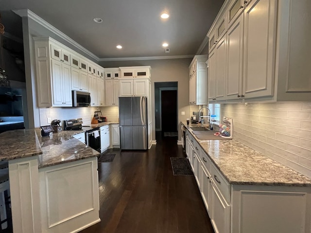 kitchen with white cabinets, dark stone countertops, sink, and stainless steel appliances