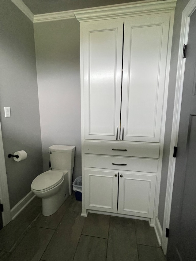 bathroom featuring tile patterned floors, toilet, and crown molding