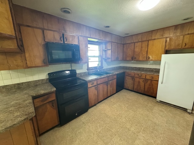2116 S Franklin St, Kirksville, MO 63501 - kitchen with black appliances, dark countertops, brown cabinetry, a textured ceiling, and light flooring