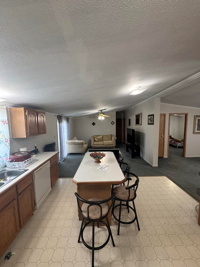 kitchen featuring white dishwasher, ceiling fan, sink, and a textured ceiling