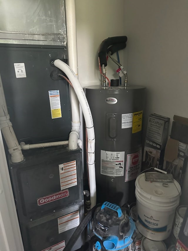 utility room featuring heating unit and electric water heater