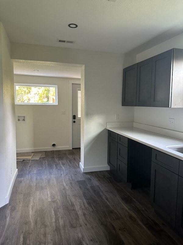 kitchen with dark hardwood / wood-style flooring, gray cabinets, and built in desk