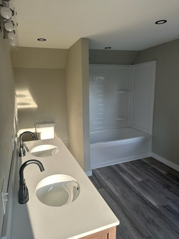 bathroom with hardwood / wood-style floors, vanity, and shower / tub combination