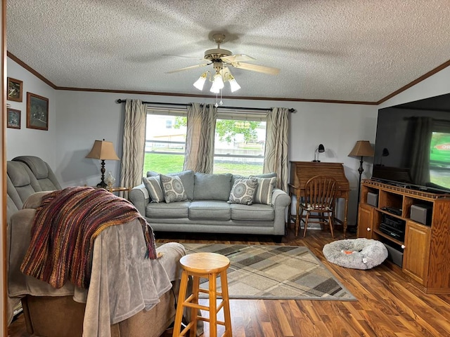 living room featuring dark hardwood / wood-style floors, vaulted ceiling, ceiling fan, and crown molding