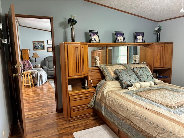 bedroom featuring hardwood / wood-style floors, a textured ceiling, vaulted ceiling, and crown molding