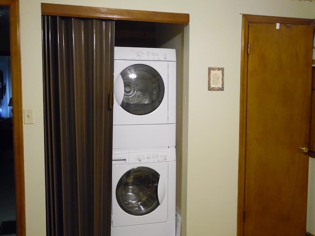 clothes washing area with stacked washer / dryer