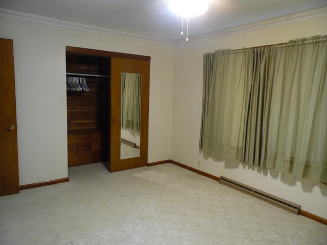 unfurnished bedroom with crown molding, a closet, light colored carpet, and a baseboard radiator