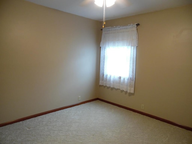 carpeted spare room with ceiling fan