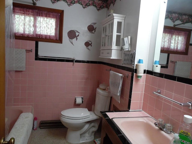 bathroom with toilet, tile walls, and a tub