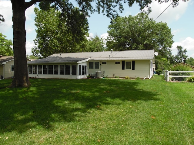 back of house featuring a sunroom, central AC, and a lawn