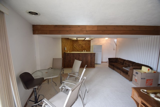 living area featuring visible vents and light carpet