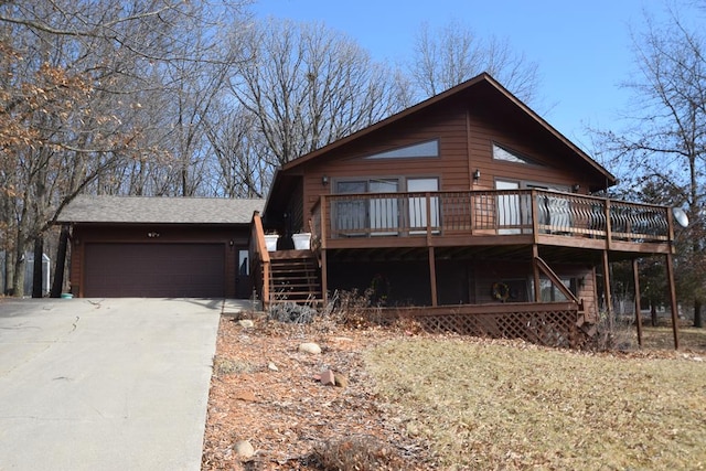 view of front of house featuring an attached garage, a wooden deck, driveway, and stairs