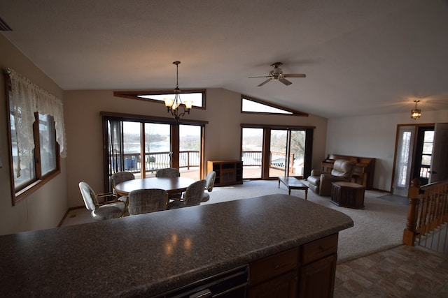 kitchen with dark countertops, open floor plan, dark carpet, pendant lighting, and lofted ceiling