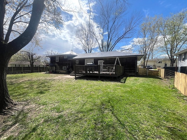 back of house featuring a yard, a fenced backyard, a wooden deck, and metal roof