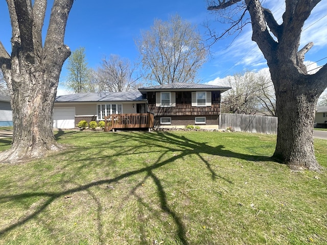 view of front of property featuring an attached garage, a front yard, a wooden deck, metal roof, and fence