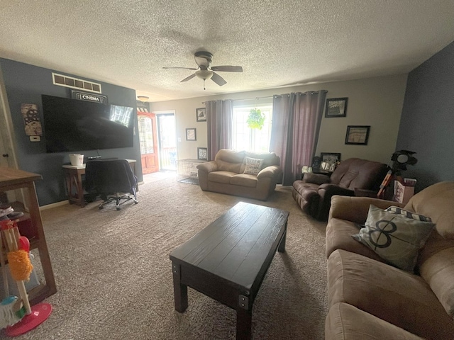 living room with carpet flooring, visible vents, a textured ceiling, and a ceiling fan