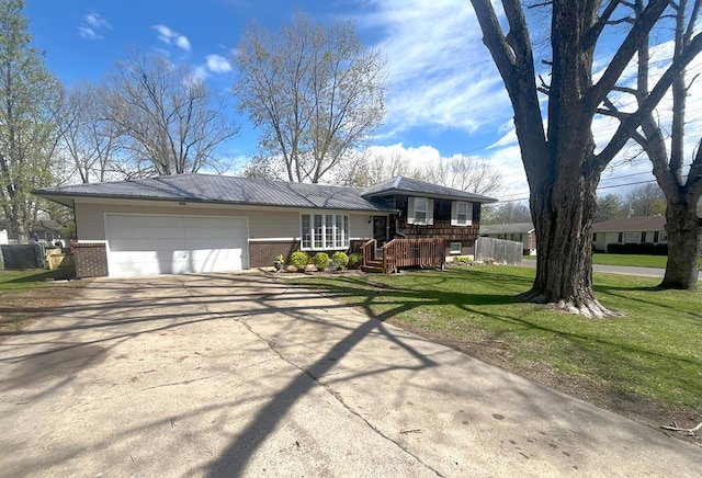 split level home with brick siding, an attached garage, a front lawn, and concrete driveway