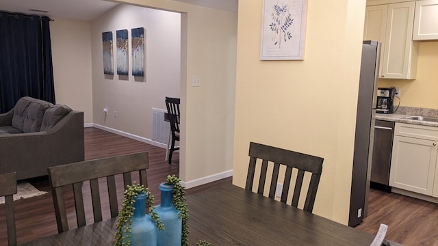 dining area with dark hardwood / wood-style flooring and sink