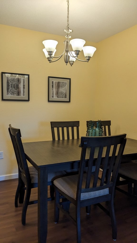 dining room featuring dark wood-type flooring and a notable chandelier