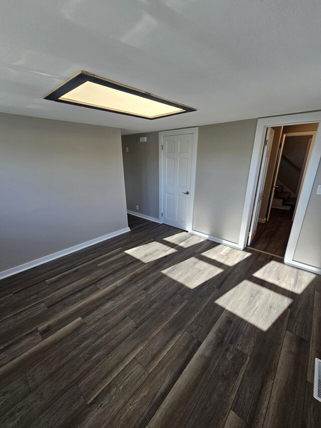 unfurnished room featuring dark wood-type flooring