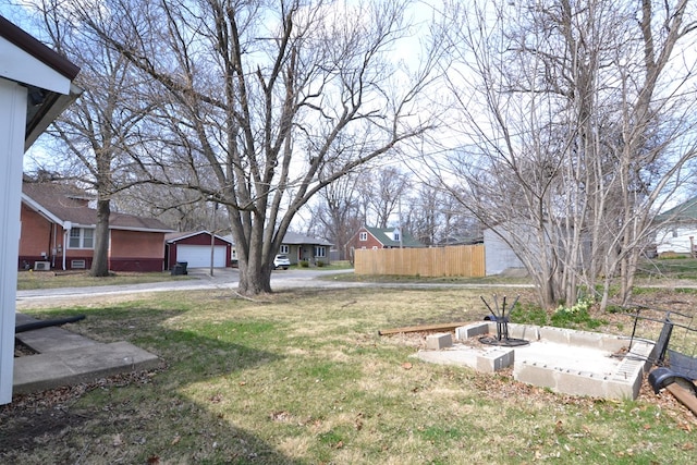view of yard with fence, driveway, and a garage