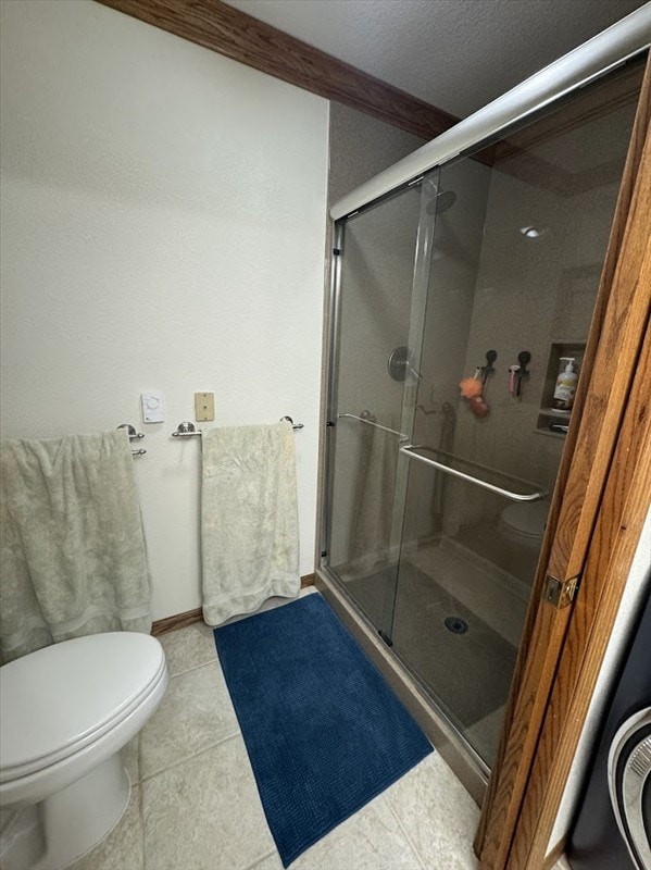 bathroom featuring walk in shower, crown molding, tile patterned floors, and toilet