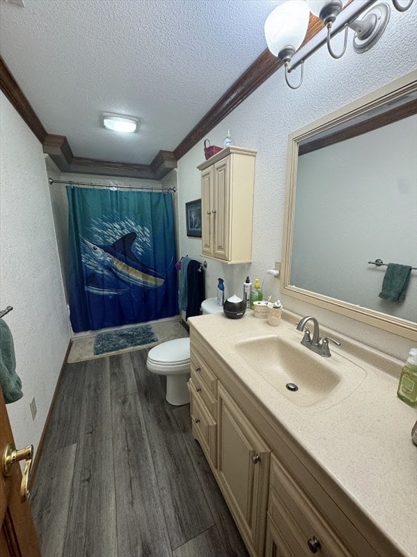 bathroom featuring a textured ceiling, ornamental molding, wood-type flooring, and vanity