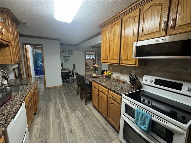 kitchen featuring white appliances, tasteful backsplash, light wood-type flooring, ornamental molding, and sink