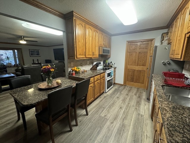 kitchen with range with two ovens, ceiling fan, and crown molding