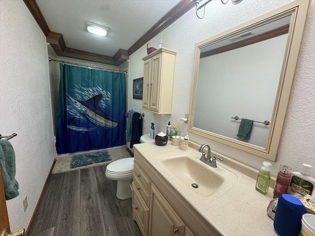 bathroom featuring a textured ceiling, hardwood / wood-style floors, ornamental molding, toilet, and vanity