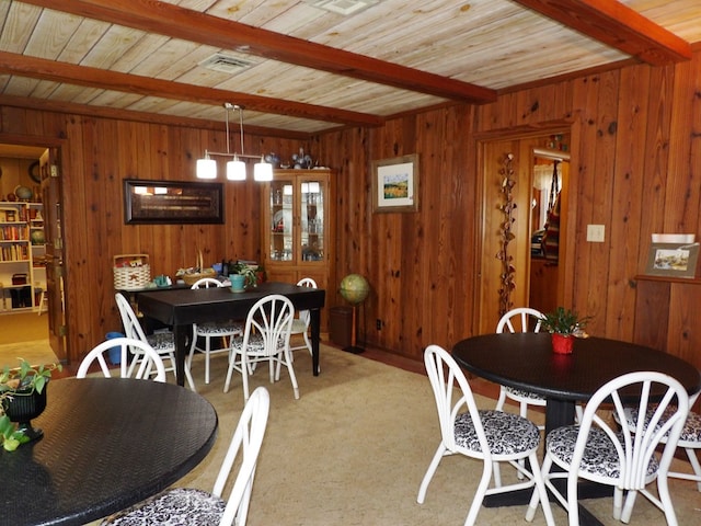 dining area featuring beamed ceiling, wooden ceiling, visible vents, and carpet floors