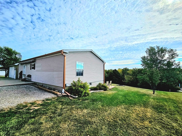 view of side of property featuring a patio and a lawn