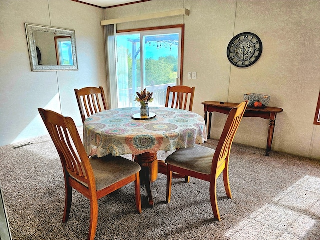 dining area featuring carpet flooring and ornamental molding