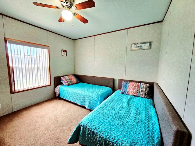 carpeted bedroom featuring ceiling fan and crown molding